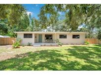 Charming single-story home features a well-manicured lawn and inviting front porch with seating, and a freshly painted exterior at 312 Palencia Pl, Lakeland, FL 33803