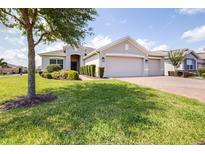 Charming single Gathering home with a well-manicured lawn, brick paved driveway and a three car garage at 3136 Langdon Ln, Winter Haven, FL 33884