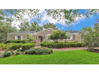 Charming brick home with manicured lawn, lush landscaping, and a welcoming front entrance at 323 E Belvedere St, Lakeland, FL 33803