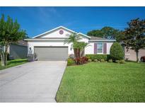 Charming single-story home featuring a well-manicured lawn and a two-car garage at 4303 Moon Shadow Loop, Mulberry, FL 33860