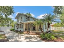 Charming light blue two-story home with a welcoming rounded porch and meticulously maintained landscaping at 516 Windsor St, Lakeland, FL 33803