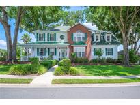 Charming two-story home boasts a brick and siding facade, complemented by lush landscaping and mature trees at 5425 Charlin Ave, Lakeland, FL 33810