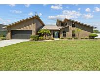 Inviting single-Gathering home featuring a well-manicured lawn and an attached two-car garage at 5519 Club W Hl, Lakeland, FL 33812