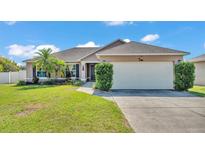 Charming single-story home with a well-manicured lawn and attached two-car garage at 555 Heather Glen Dr, Winter Haven, FL 33884