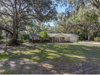 Charming single-story brick home featuring a well-manicured lawn and mature trees, creating a serene and inviting curb appeal at 5624 Laurel Oak Dr, Lakeland, FL 33811