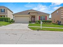 Charming one-story home boasts stone accents, a two-car garage, and well-maintained landscaping in a suburban neighborhood at 5793 Dornich Dr, Auburndale, FL 33823