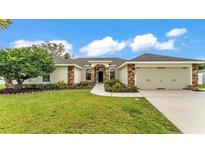 Charming single-story home features a well-manicured lawn, lush landscaping, and an attached two-car garage at 601 Pintail Cir, Auburndale, FL 33823