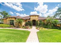Inviting home with manicured lawn and beautiful landscaping, featuring a brick walkway to the front door at 6357 Ashley Dr, Lakeland, FL 33813