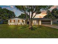 Charming single-story home featuring a well-manicured lawn, painted brick, and a sleek black roof at 6543 Tula Ln, Lakeland, FL 33809