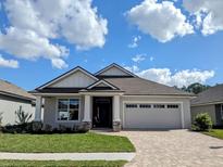 Beautiful single story home featuring manicured lawn, craftsman columns, and brick paver driveway and walkway at 7919 Lake James Blvd, Lakeland, FL 33810