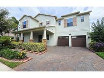 Inviting two-story home featuring a brick driveway and meticulous landscaping at 13525 Gorgona Isle Dr, Windermere, FL 34786