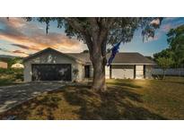 Charming single-story home featuring a well-maintained lawn, mature trees, and an attached two-car garage at 1423 Ridgegreen N Loop, Lakeland, FL 33809