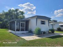 Charming single-story home with a screened-in porch and well-maintained landscaping at 2005 Blue Lake Dr, Lakeland, FL 33801