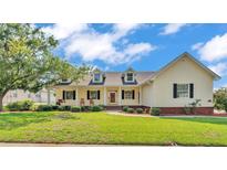 Charming one-story home with a manicured front lawn, covered porch with swing, and dormer windows at 2025 Viewpoint Landings Rd, Lakeland, FL 33810