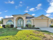 Charming home exterior with landscaped yard, double door entry, and attached two-car garage at 2255 Couples Dr, Lakeland, FL 33813