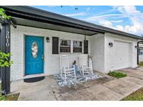 Charming front porch with a blue door, white rocking chairs, and brick exterior, offering a cozy entrance at 2810 Gary Ln, Lakeland, FL 33812