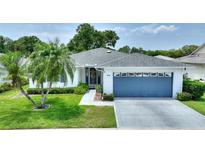 Charming single-story home with a well-manicured lawn and attached blue two-car garage at 3618 Highland Fairways Blvd, Lakeland, FL 33810