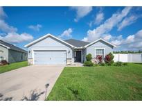 Charming single-Gathering home with a well-manicured lawn, stone accents, and a two-car garage on a beautiful day at 3883 Sandhill Crane Dr, Lakeland, FL 33811