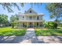 Charming two-story home with a welcoming front porch and lush landscaping at 645 E Church St, Bartow, FL 33830