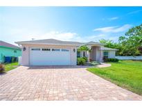 Charming single-story home with a well-manicured lawn, paver driveway, and an attached two-car garage at 7016 Summit Cir, Winter Haven, FL 33884