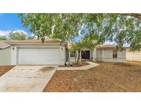 Charming single-story home with a two-car garage, well-maintained lawn, and mature shade trees at 7311 Briarbay Loop, Lakeland, FL 33810