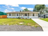 Charming single story home featuring a well-manicured lawn and a classic white and gray exterior at 808 Austin Cir, Bartow, FL 33830