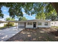 Charming single-story home boasting a carport, a dark front door and large windows at 3813 Surrey Dr, Orlando, FL 32812