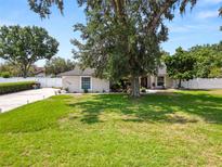 Beautifully landscaped front yard featuring a mature tree and well-maintained lawn, complementing this charming home at 1130 Ewell Rd, Lakeland, FL 33811
