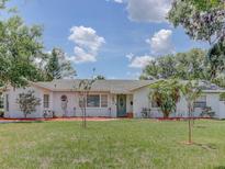 Charming single-story home featuring a well-manicured lawn and beautiful landscaping at 1195 S 1St Ave, Bartow, FL 33830