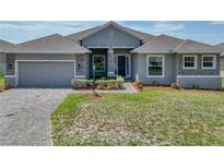 Beautiful single-story home with a two-car garage, stone accents, and a well-maintained lawn at 1547 Cordgrass Way, Lakeland, FL 33813
