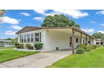 Well-maintained home featuring a covered carport, manicured lawn, and charming curb appeal at 1602 Tally Ho Dr, Lakeland, FL 33810