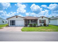 Charming single-story home featuring a screened-in porch, well-maintained lawn, and attached two-car garage at 1608 Colonnades N Cir, Lakeland, FL 33811