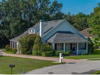 Charming home featuring a brick driveway, a cozy front porch, and lush, mature landscaping at 184 Melissa Trl, Auburndale, FL 33823