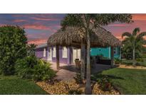 Charming home exterior with a tiki hut, perfect for outdoor entertaining and relaxation at 3052 Wood Duck Dr, Polk City, FL 33868