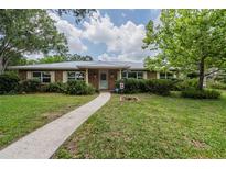 Charming brick home featuring a metal roof and lush landscaping in the front yard at 4006 Glen Garry W Rd, Lakeland, FL 33813