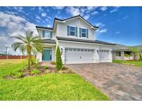 Charming two-story home showcasing a three-car garage, a blue entry door, and manicured front lawn at 4449 Juliana Lake Dr, Auburndale, FL 33823