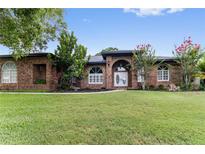 Charming single-story brick home with lush front lawn and mature landscaping at 4642 Highlands Place Dr, Lakeland, FL 33813
