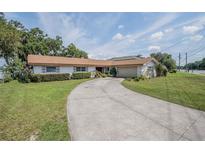 Charming single-story home featuring a well-manicured lawn and long driveway at 5026 N Socrum Loop Rd, Lakeland, FL 33809