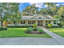 Charming single-story home features a large front porch, manicured lawn, and lush landscaping at 5108 Waterwood Dr, Bartow, FL 33830