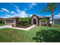 Charming single-story home with a well-manicured lawn, stone accents, and a two-car garage at 6339 Alamanda Hills Dr, Lakeland, FL 33813