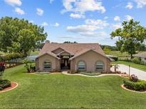 Charming single-story home featuring a well-manicured lawn and mature trees in a peaceful setting at 7932 Ridge Pointe W Dr, Lakeland, FL 33810