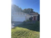 Charming single-story home with a well-maintained lawn and a two-car garage at 1410 Bramblewood Dr, Lakeland, FL 33811