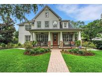 Charming two-story home featuring a welcoming front porch, manicured lawn, and lush landscaping at 1825 Pawnee Trl, Lakeland, FL 33803