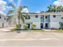 Two-story townhouse with light blue siding, white accents, and a well-maintained landscaped front at 222 Carpenters Way # 65, Lakeland, FL 33805