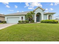 Charming home featuring a manicured lawn, complemented by lush landscaping and a welcoming light blue exterior at 2593 Colonel Ford Dr, Lakeland, FL 33813