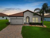 Charming single-story home featuring a tile roof, arched entryway and lush landscaping at 4125 Prima Lago Cir, Lakeland, FL 33810