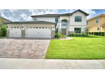 Beautiful two-story home featuring a three-car garage, brick driveway and pristine landscaping at 4312 Juliana Lake Dr, Auburndale, FL 33823