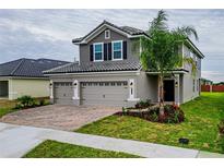 Charming two-story home with a well-manicured lawn, brick driveway, and a two-car garage at 4407 Juliana Lake Dr, Auburndale, FL 33823