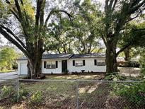 Charming single-story home with white paint and mature trees in a fenced yard at 4535 Weston Ct, Bartow, FL 33830