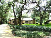Charming home with stone accents, mature trees, and lush landscaping at 5070 Ironwood Trl, Bartow, FL 33830